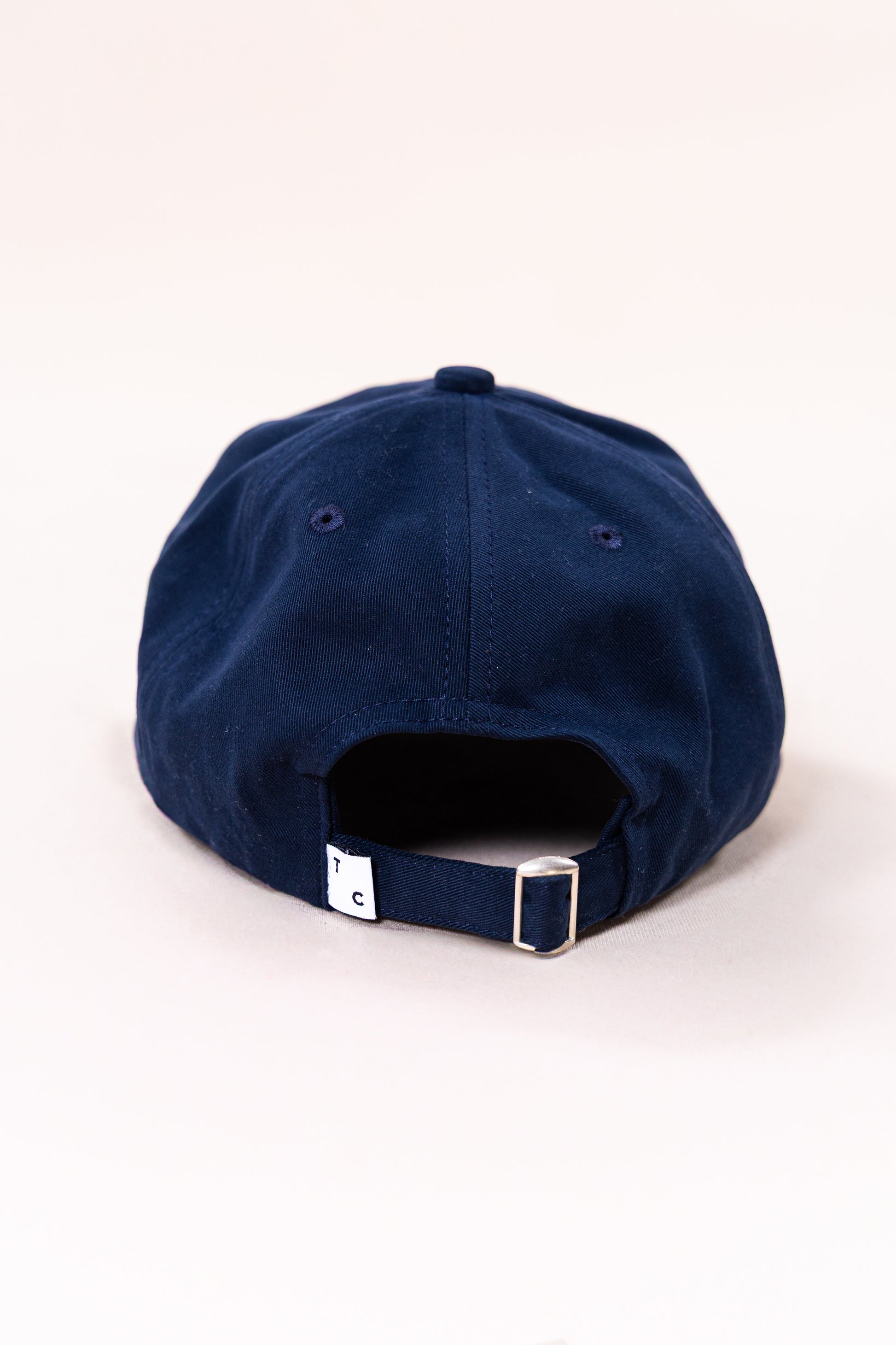 Boné de sarja azul marinho Thomson Club, fabricado em 100% algodão com sarja esmerilada para um toque macio e acabamento premium. Design clássico de seis painéis, tamanho único com fecho ajustável e ajustador de metal em prata velha. Faixa de cabeça reforçada e logotipo bordado. Perfeito para um estilo casual sofisticado e conforto duradouro.