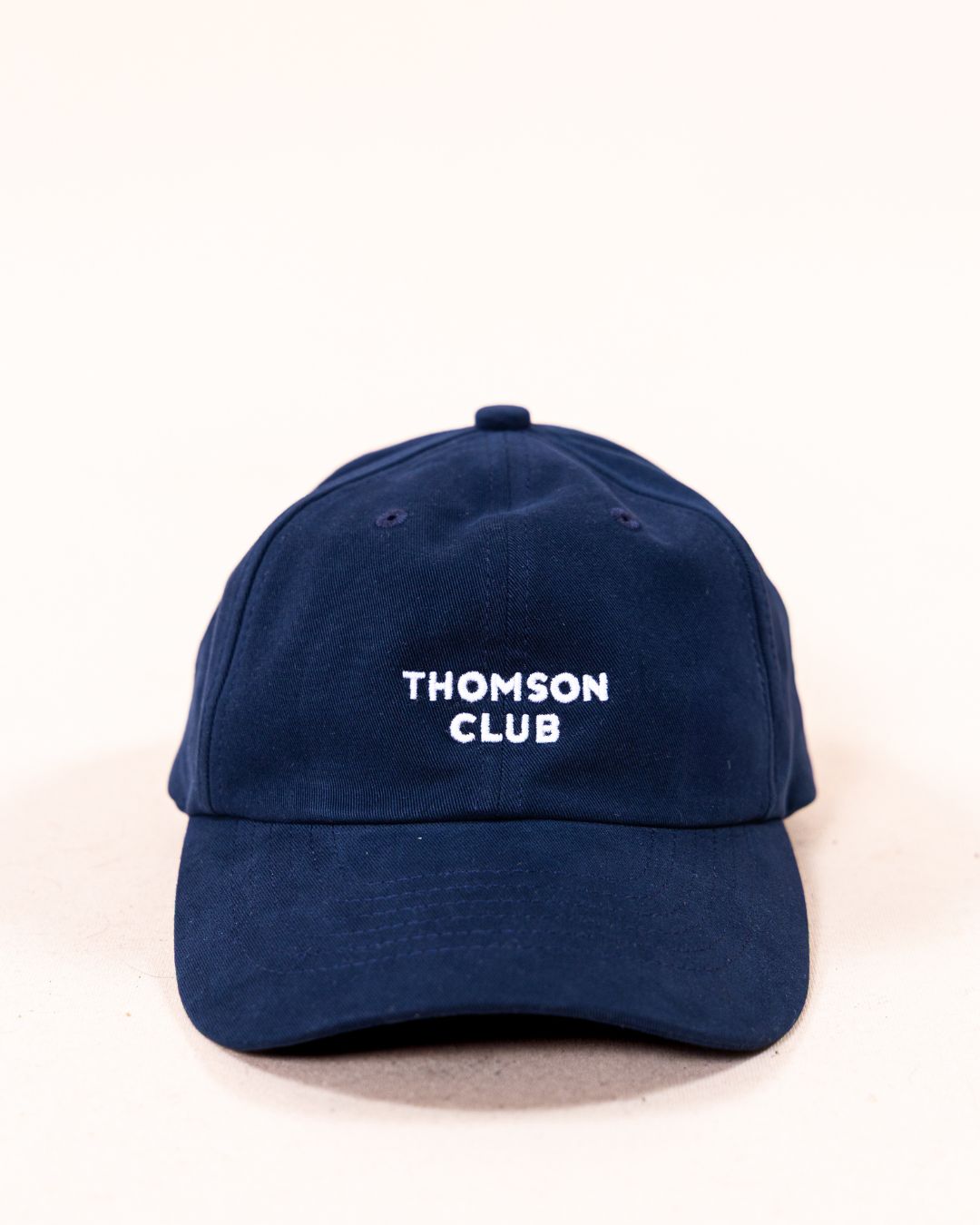 Boné de sarja azul marinho Thomson Club, fabricado em 100% algodão com sarja esmerilada para um toque macio e acabamento premium. Design clássico de seis painéis, tamanho único com fecho ajustável e ajustador de metal em prata velha. Faixa de cabeça reforçada e logotipo bordado. Perfeito para um estilo casual sofisticado e conforto duradouro.