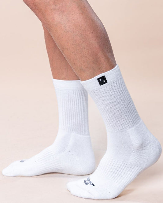 Meias TC brancas em algodão macio (80% algodão, 15% poliamida, 5% elastano). Design sem costura para máximo conforto. Altura de 12 cm do calcanhar ao topo, logotipo Thomson Club em jacquard e etiqueta TC preta. Perfeitas para uso diário.
