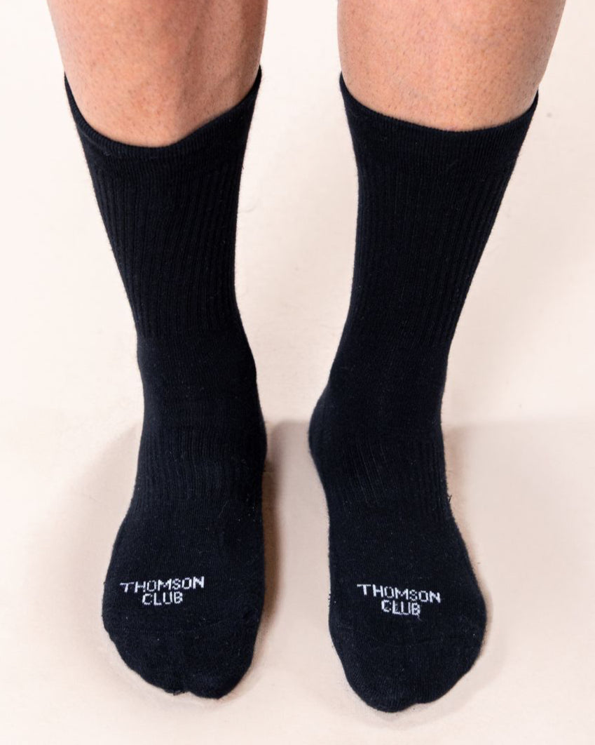 Meias TC pretas em algodão macio (80% algodão, 15% poliamida, 5% elastano). Design sem costura para máximo conforto. Altura de 12 cm do calcanhar ao topo, logotipo Thomson Club em jacquard e etiqueta TC preta. Perfeitas para uso diário.