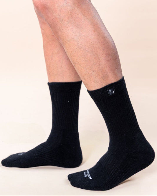 Meias TC pretas em algodão macio (80% algodão, 15% poliamida, 5% elastano). Design sem costura para máximo conforto. Altura de 12 cm do calcanhar ao topo, logotipo Thomson Club em jacquard e etiqueta TC preta. Perfeitas para uso diário.