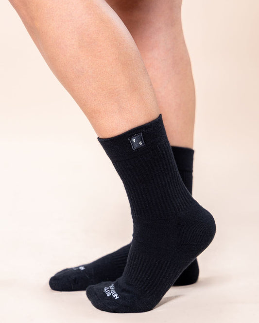 Meias TC pretas em algodão macio (80% algodão, 15% poliamida, 5% elastano). Design sem costura para máximo conforto. Altura de 12 cm do calcanhar ao topo, logotipo Thomson Club em jacquard e etiqueta TC preta. Perfeitas para uso diário.pretas