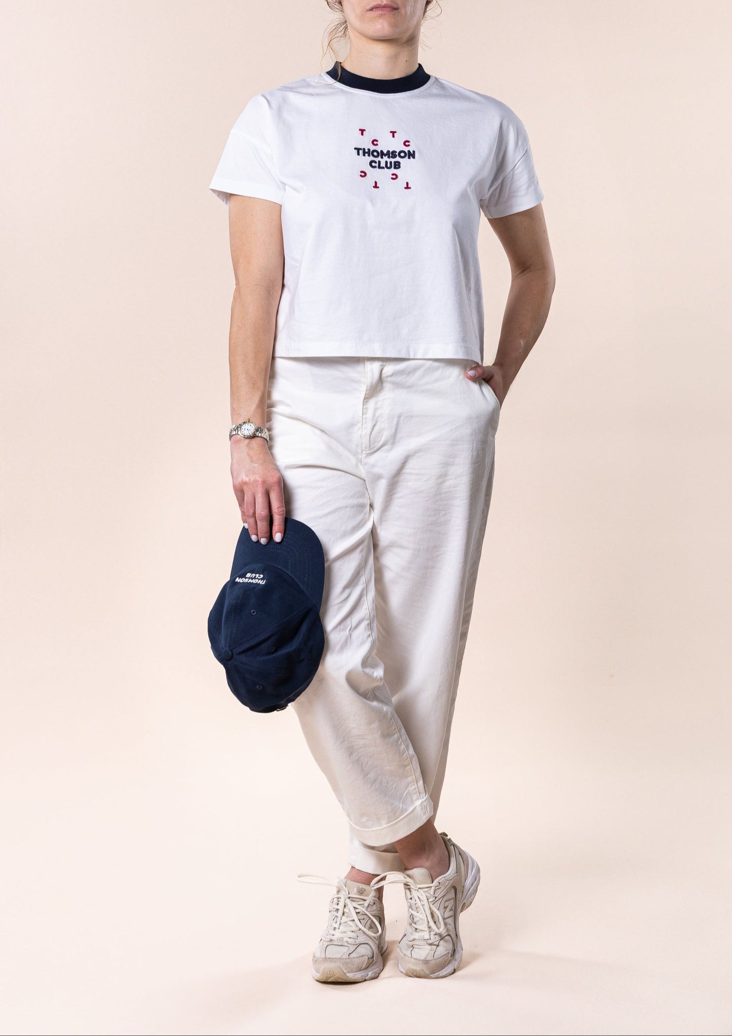 T-shirt feminina branca confecionada em 100% algodão orgânico, jersey de 200g, com corte ligeiramente curto mas relaxado. Apresenta gola em rib 1x1, costuras detalhadas de alta qualidade, meia-lua nas costas para maior conforto, bordado em relevo Thomson Club e tag metálica em prata velha. Produção sustentável e design sofisticado, ideal para diversas ocasiões.